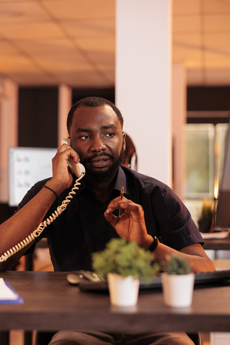 Male freelancer talking to people on landline phone